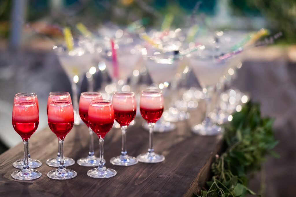 Set of red cocktails on the bar counter. Night club, evening party. Lights bokeh on background